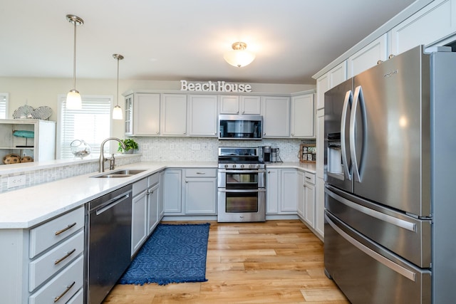 405 Anchors Way, Saint Joseph, MI 49085 - kitchen with appliances with stainless steel finishes, a sink, backsplash, and a peninsula