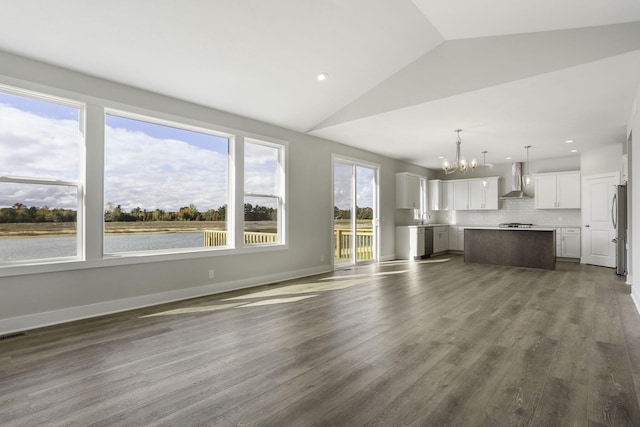 9423 Shoreway Dr, West Olive, MI 49460 - unfurnished living room with a chandelier, plenty of natural light, vaulted ceiling, dark wood finished floors, and a sink