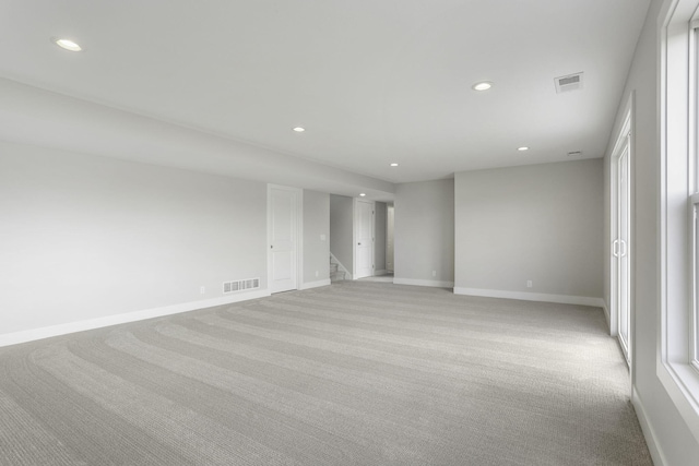9423 Shoreway Dr, West Olive, MI 49460 - spare room featuring light carpet, recessed lighting, baseboards, and stairway