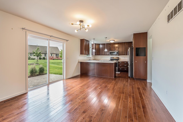 6837 Wellington Dr, Dexter, MI 48130 - kitchen with stainless steel appliances, dark brown cabinets, light countertops, dark wood finished floors, and a peninsula