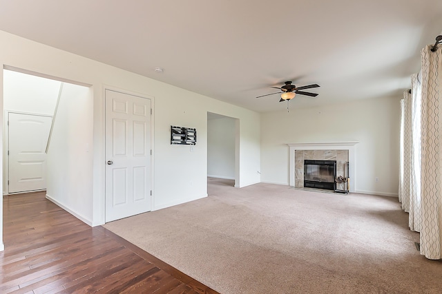 6837 Wellington Dr, Dexter, MI 48130 - unfurnished living room with a ceiling fan, a fireplace, baseboards, carpet flooring, and wood finished floors