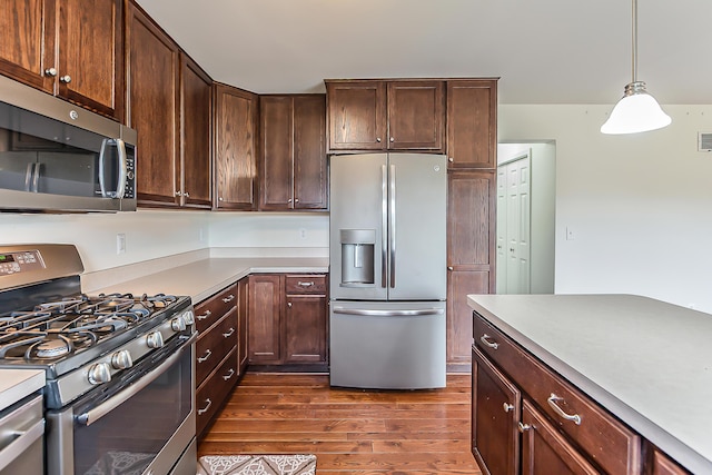 6837 Wellington Dr, Dexter, MI 48130 - kitchen featuring appliances with stainless steel finishes, dark wood-style floors, light countertops, and dark brown cabinets