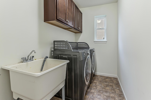 6837 Wellington Dr, Dexter, MI 48130 - washroom featuring baseboards, independent washer and dryer, cabinet space, and stone finish floors