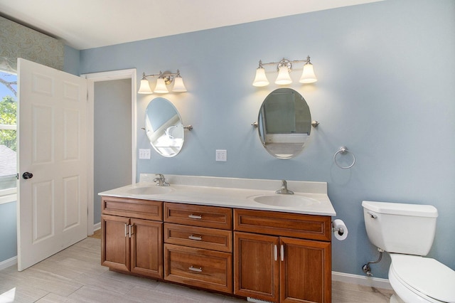 2314 Hickory Point Dr N, Portage, MI 49024 - bathroom featuring toilet, double vanity, baseboards, and wood finished floors