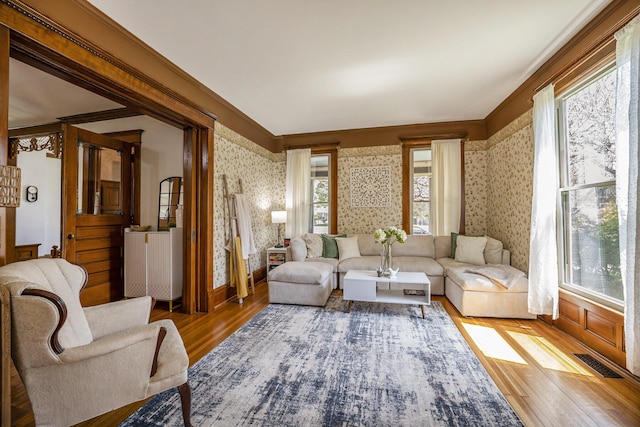 210 E St, Three Rivers, MI 49093 - living room with wallpapered walls, wood finished floors, healthy amount of natural light, and baseboards