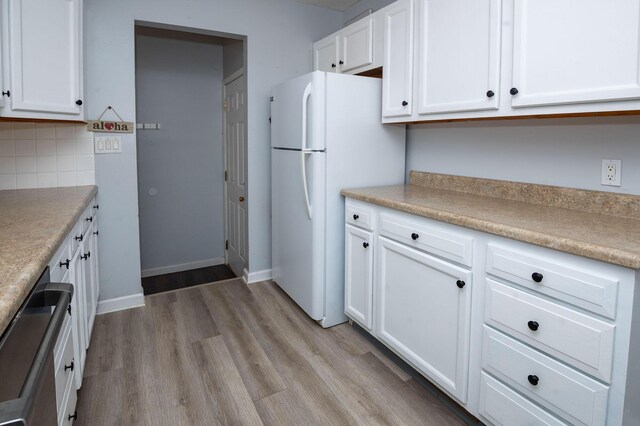 9017 N Main St, Berrien Springs, MI 49103 - kitchen with freestanding refrigerator, white cabinetry, light wood finished floors, tasteful backsplash, and light countertops