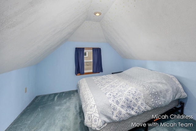 carpeted bedroom with vaulted ceiling and a textured ceiling
