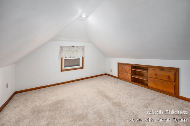 additional living space with carpet floors, baseboards, and vaulted ceiling
