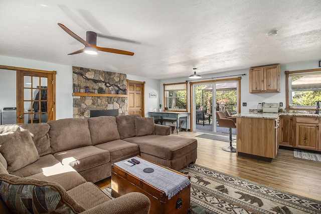 3897 N Chief Pontiac Trl, Branch, MI 49402 - living area with wood finished floors, ceiling fan, and a stone fireplace