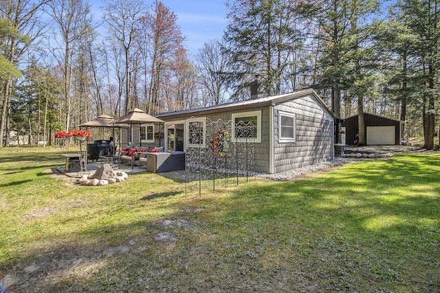 3897 N Chief Pontiac Trl, Branch, MI 49402 - rear view of house featuring a garage, an outdoor structure, a chimney, a yard, and outdoor lounge area