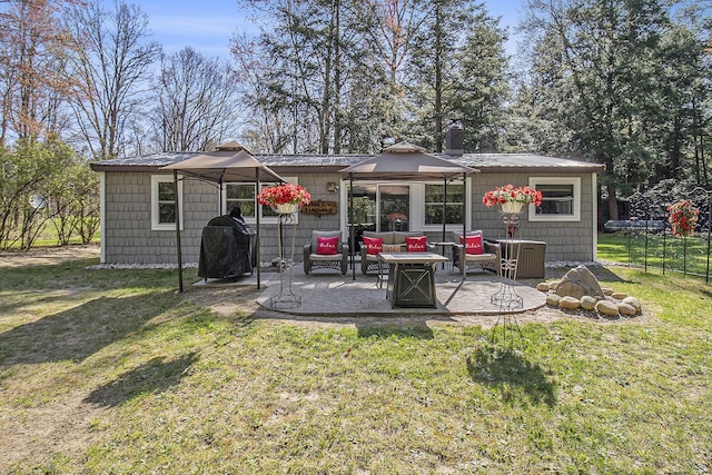 3897 N Chief Pontiac Trl, Branch, MI 49402 - rear view of house with an outdoor fire pit, a patio area, and a chimney