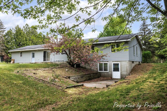 315 Hayes St NW, Comstock Park, MI 49321 - rear view of house with a lawn and a patio area
