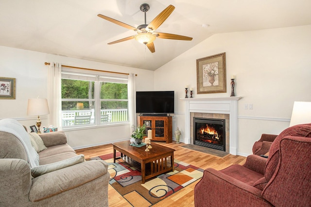 232 Embury Dr, Battle Creek, MI 49014 - living area featuring lofted ceiling, a tile fireplace, light wood-type flooring, and a ceiling fan