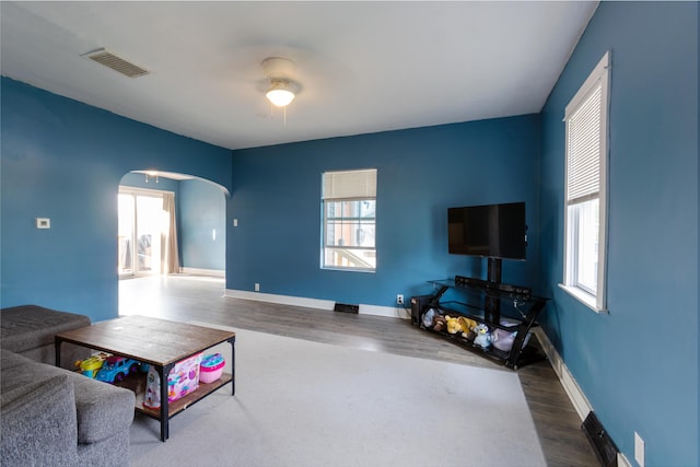 104 S Lowe St, Dowagiac, MI 49047 - living room featuring arched walkways, healthy amount of natural light, ceiling fan, and wood finished floors