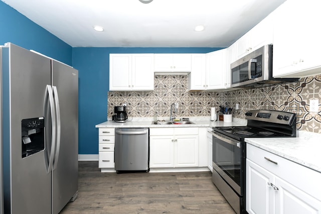 104 S Lowe St, Dowagiac, MI 49047 - kitchen featuring appliances with stainless steel finishes, a sink, white cabinets, dark wood-type flooring, and backsplash
