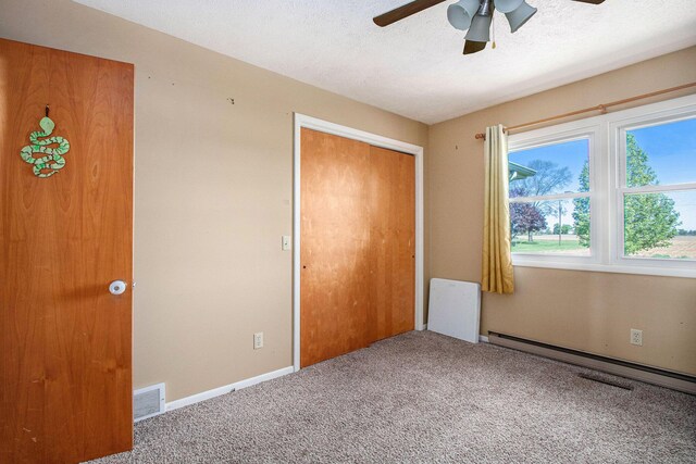 32867 Middle Crossing Rd, Dowagiac, MI 49047 - unfurnished bedroom with carpet flooring, a closet, baseboard heating, a ceiling fan, and a textured ceiling