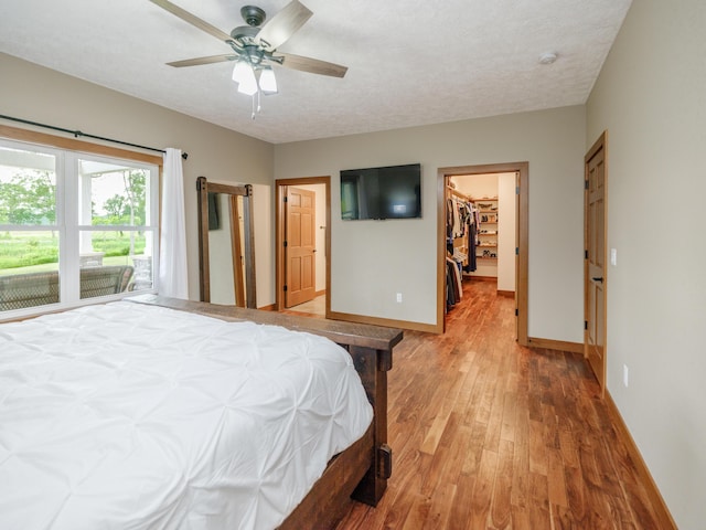 1518 M Dr S, East Leroy, MI 49051 - bedroom featuring light wood-style flooring, a spacious closet, a ceiling fan, and a closet