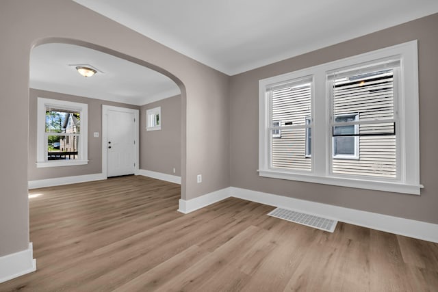 16568 Monica St, Detroit, MI 48221 - spare room featuring arched walkways, baseboards, and light wood finished floors