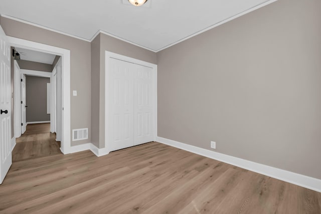 16568 Monica St, Detroit, MI 48221 - unfurnished bedroom with light wood finished floors, crown molding, a closet, and baseboards
