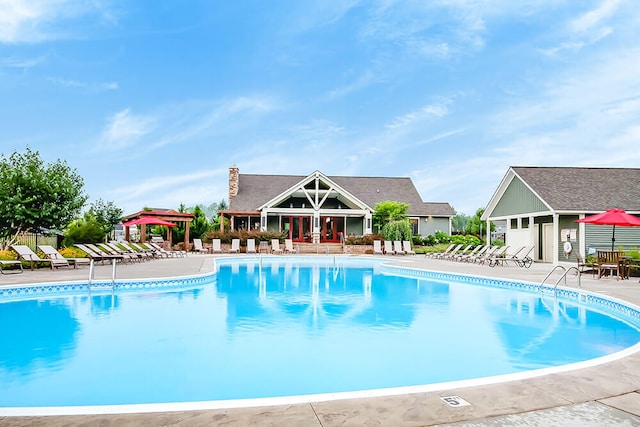 community pool with a patio, a gazebo, and fence