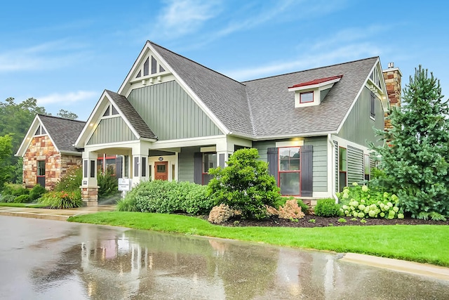view of front of property with board and batten siding, a chimney, and a shingled roof