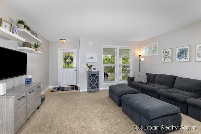 living room featuring light carpet, healthy amount of natural light, and baseboards