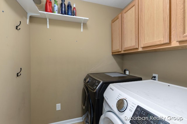 clothes washing area featuring separate washer and dryer and cabinet space