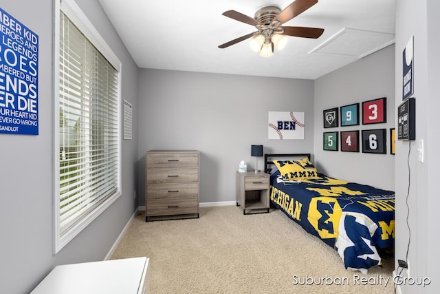 carpeted bedroom featuring baseboards, ceiling fan, and attic access