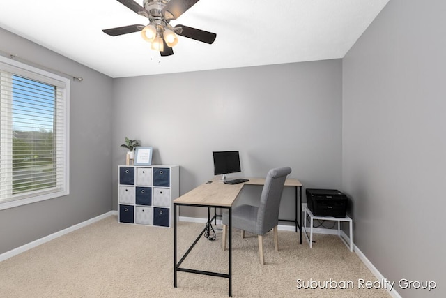 home office featuring baseboards, a ceiling fan, and carpet