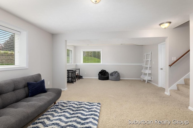 carpeted living area with plenty of natural light, baseboards, and stairway