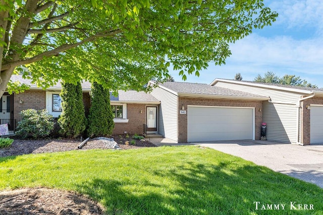 940 Laketown Dr, Holland, MI 49423 - view of front of property with brick siding, a garage, a front lawn, and driveway