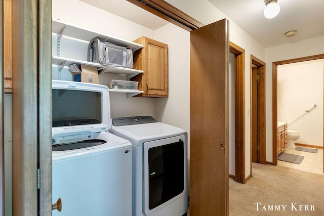940 Laketown Dr, Holland, MI 49423 - laundry room featuring cabinet space, washing machine and clothes dryer, light colored carpet, and baseboards