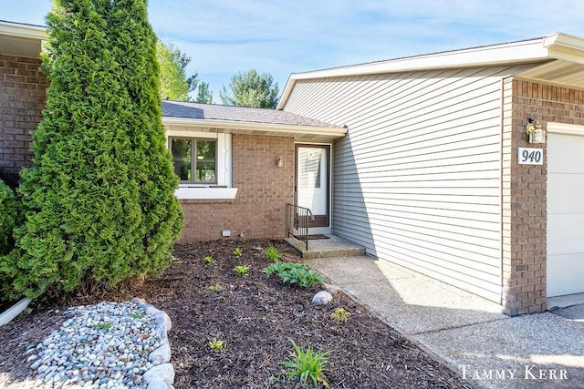 940 Laketown Dr, Holland, MI 49423 - view of exterior entry featuring brick siding and a shingled roof