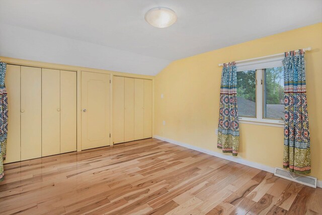 1514 Ferndale Blvd, Niles, MI 49120 - unfurnished bedroom with multiple closets, light wood-style flooring, vaulted ceiling, and baseboards