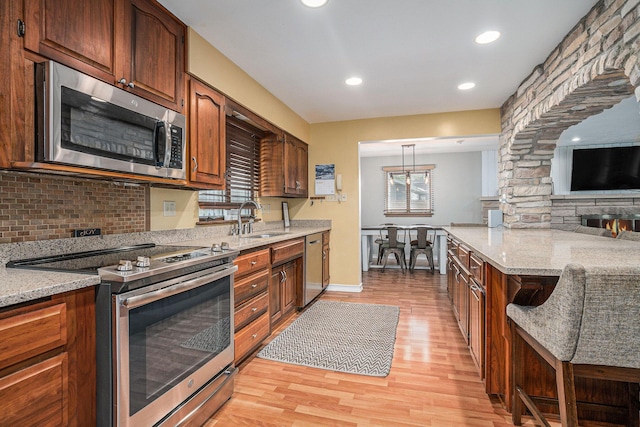1514 Ferndale Blvd, Niles, MI 49120 - kitchen with appliances with stainless steel finishes, a sink, light wood-style flooring, tasteful backsplash, and light stone countertops