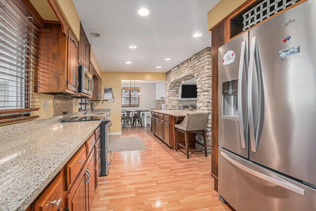 1514 Ferndale Blvd, Niles, MI 49120 - kitchen with appliances with stainless steel finishes, light wood finished floors, recessed lighting, light stone counters, and brown cabinetry