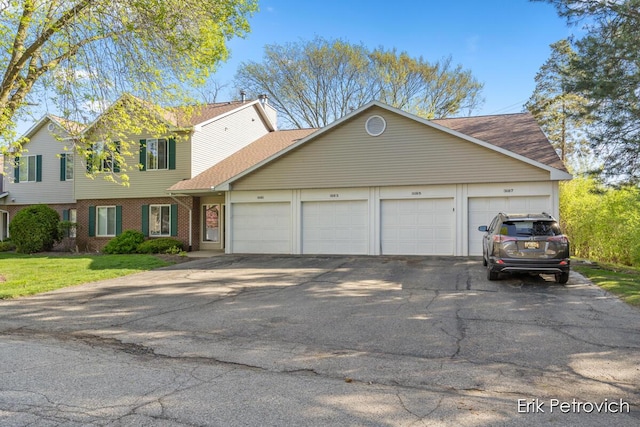 3185 Windcrest Dr NE, Grand Rapids, MI 49525 - view of front of house with driveway, a shingled roof, and brick siding