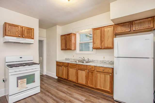 918 Kalamazoo Ave SE, Grand Rapids, MI 49507 - kitchen with white appliances, under cabinet range hood, wood finished floors, a sink, and brown cabinets