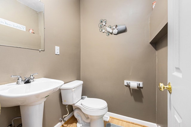 13195 Rainbow Dr, Gregory, MI 48137 - half bath featuring baseboards, wood finished floors, toilet, and a sink