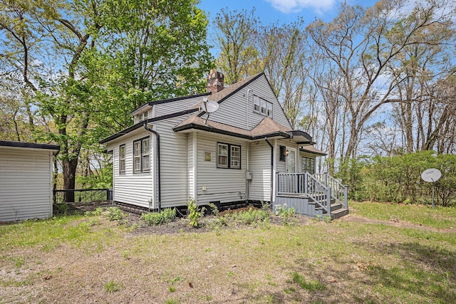 7566 Red Arrow Hwy, Stevensville, MI 49127 - view of home's exterior featuring a chimney, a yard, and roof with shingles