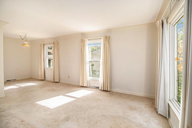 carpeted empty room featuring baseboards