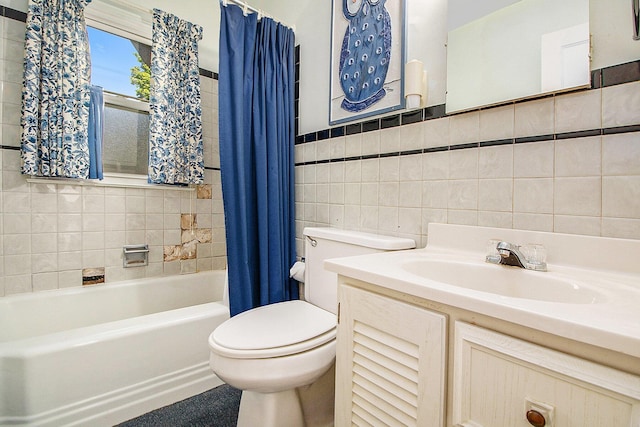 full bath featuring tile walls, toilet, vanity, and shower / tub combo with curtain