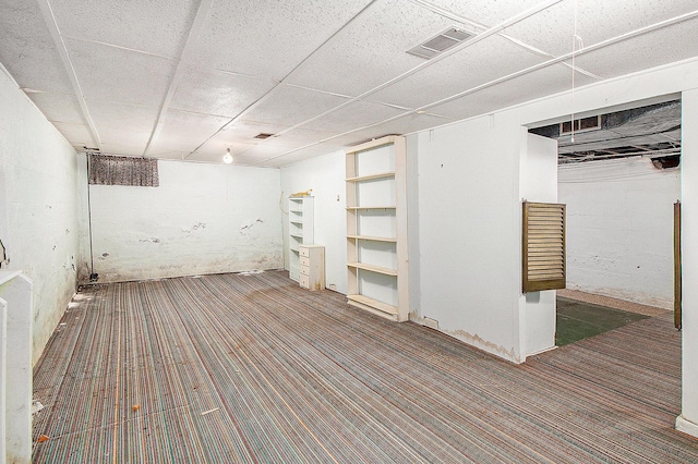 finished below grade area featuring carpet and a drop ceiling