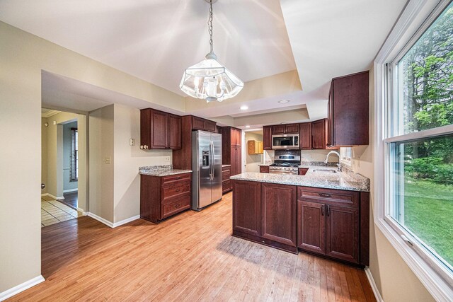 3630 Charter Pl, Ann Arbor, MI 48105 - kitchen featuring appliances with stainless steel finishes, a sink, light wood-style flooring, baseboards, and a peninsula