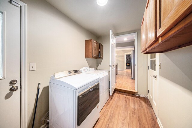 3630 Charter Pl, Ann Arbor, MI 48105 - laundry area with cabinet space, light wood finished floors, and washing machine and clothes dryer