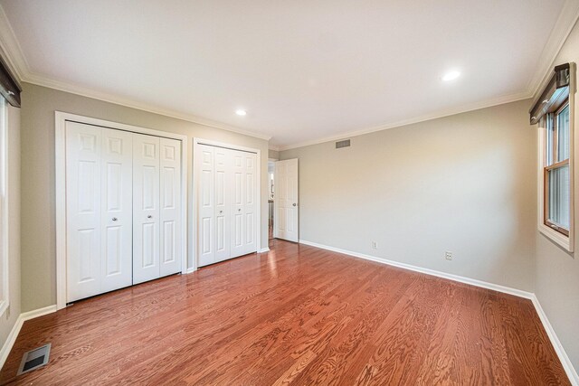 3630 Charter Pl, Ann Arbor, MI 48105 - unfurnished bedroom featuring wood finished floors, multiple closets, ornamental molding, baseboards, and recessed lighting