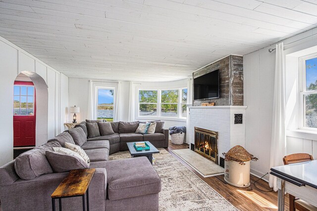 8700 E Napier Ave, Benton Harbor, MI 49022 - living room featuring wood finished floors, wooden ceiling, arched walkways, and a brick fireplace