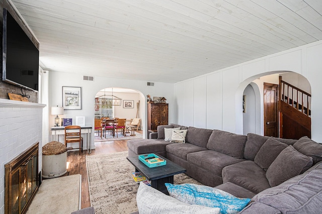 8700 E Napier Ave, Benton Harbor, MI 49022 - living area with arched walkways, wood finished floors, a brick fireplace, wooden ceiling, and a decorative wall