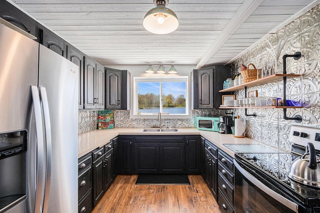 8700 E Napier Ave, Benton Harbor, MI 49022 - kitchen with appliances with stainless steel finishes, a sink, light countertops, backsplash, and light wood-type flooring