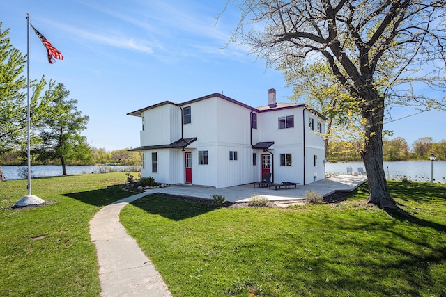 8700 E Napier Ave, Benton Harbor, MI 49022 - back of house with a chimney, a water view, a patio, and a lawn